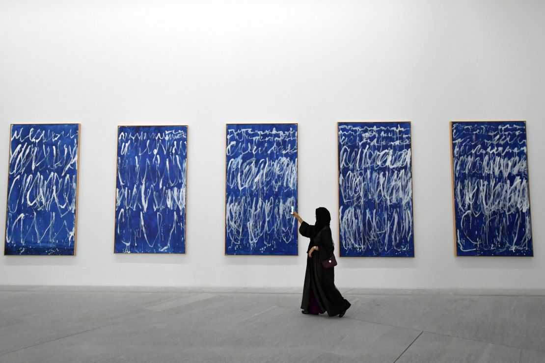 A visitor takes a photo of a piece of a series of nine panels titled "Untitled I-IX" by American artist Cy Twombly at the Louvre Abu Dhabi Museum on November 11.