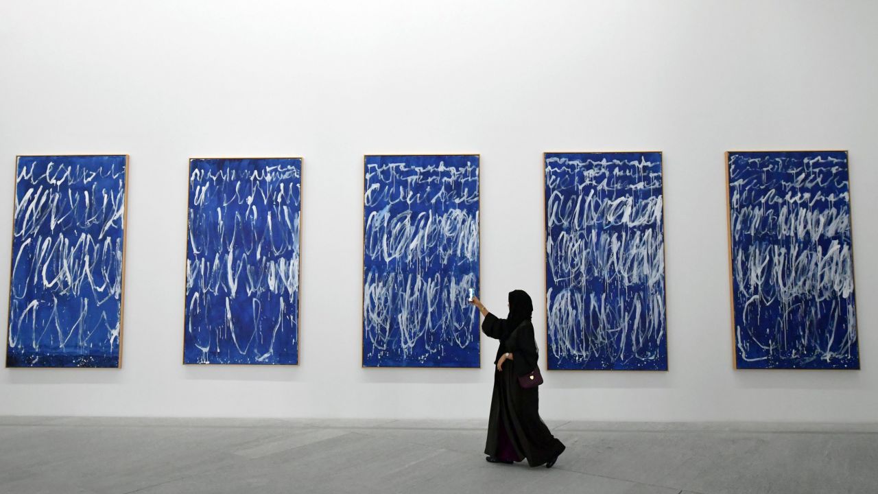 A visitor takes a photo of a piece of a series of nine panels titled "Untitled I-IX" by American artist Cy Twombly at the Louvre Abu Dhabi Museum on November 11.