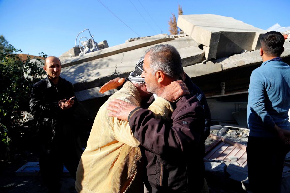 Two earthquake survivors embrace at the site of a collapsed building in Iraq's Darbandikhan district.