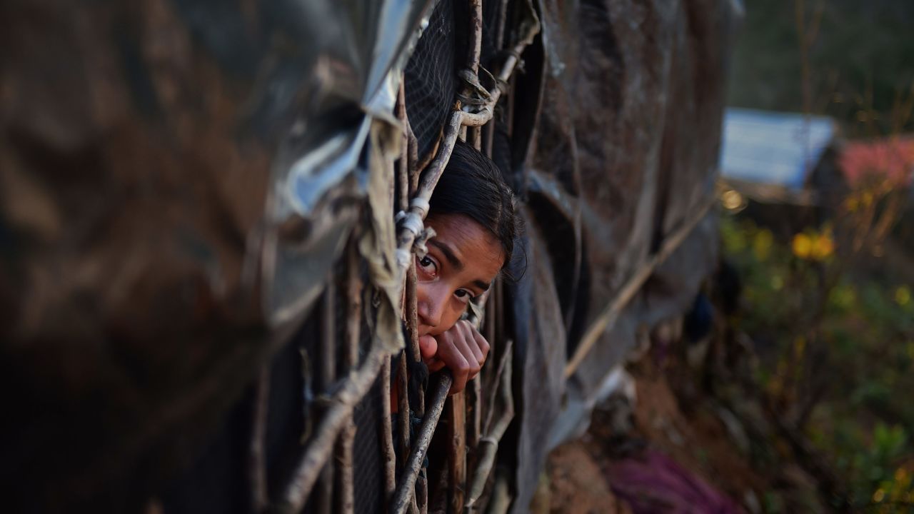 A Rohingya girl looks out from a makeshift shelter in the Bangladeshi district of Ukhia.