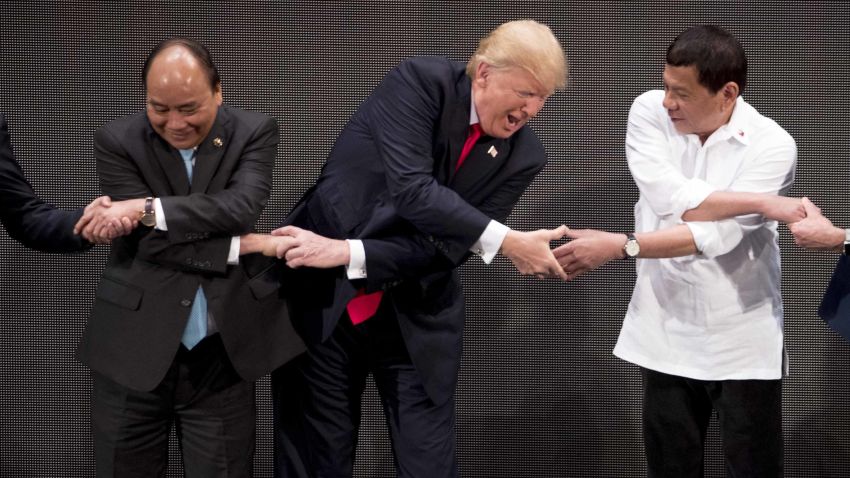 U.S. President Donald Trump, center, reacts as he does the "ASEAN-way handshake" with Vietnamese Prime Minister Nguyen Xuan Phuc, left, and Philippine President Rodrigo Duterte on stage during the opening ceremony at the ASEAN Summit at the Cultural Center of the Philippines, Monday, Nov. 13, 2017, in Manila, Philippines. Trump initially did the handshake incorrectly. Trump is on a five-country trip through Asia traveling to Japan, South Korea, China, Vietnam and the Philippines. (AP Photo/Andrew Harnik)