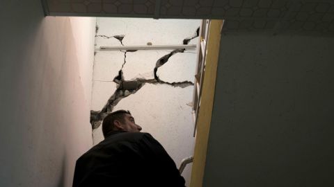 A man checks the interior of a damaged house after an earthquake in the city of Darbandikhan.