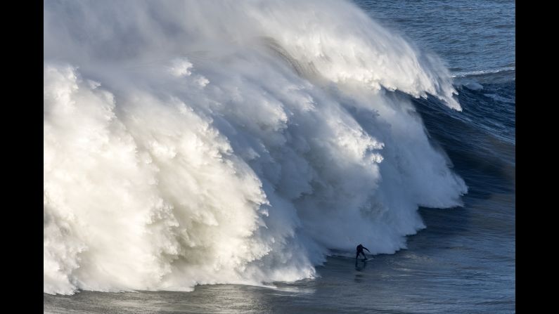 A massive wave trails British surfer Andrew Cotton during a session in Nazare, Portugal, on Wednesday, November 8. Cotton suffered a broken back <a href="index.php?page=&url=http%3A%2F%2Fwww.cnn.com%2Fvideos%2Fus%2F2017%2F11%2F10%2Fsurfer-breaks-back-after-massive-wipeout-lc-orig.cnn" target="_blank">after being knocked off his board.</a>