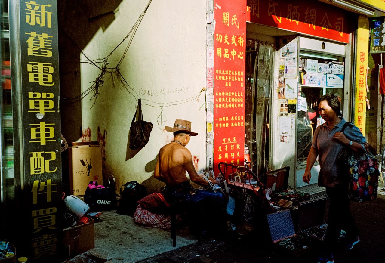 <strong>Sunday Market:</strong> "Old neighborhoods such as Sham Shui Po are surrounded by little flea markets where you can find the most random items. To me, this is old Hong Kong. Just like in Sai Ying Pun, you can capture great contrast lighting with the buildings. In this image, I wanted to capture the man with the cowboy hat before he turned around, so I shot this quite quickly. I never intended to get this lady -- I think she walked into the frame. I don't mind it at all, I actually think it helps the composition and I also love the contrast."