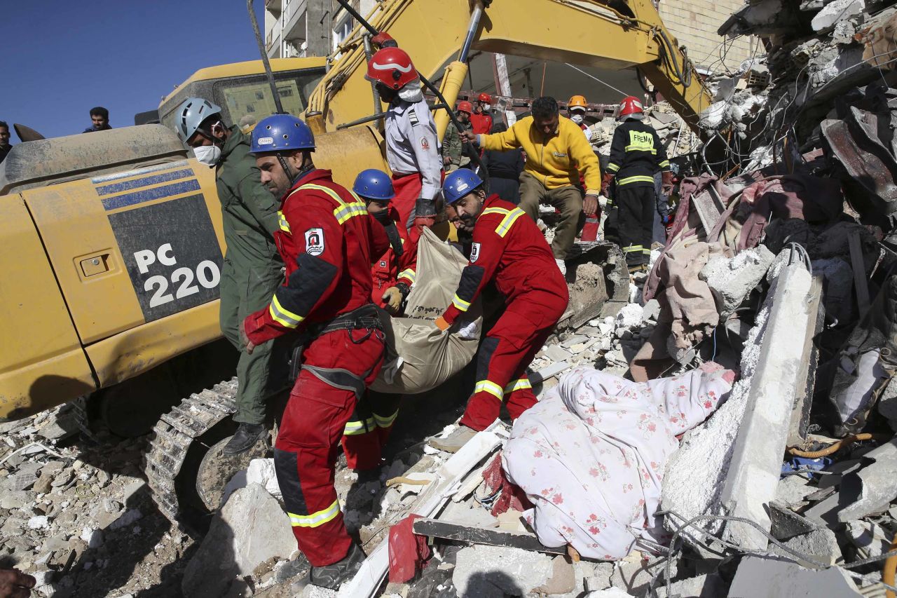 Members of the emergency services carry away the body of an earthquake victim in Sarpol-e-Zahab on November 14.
