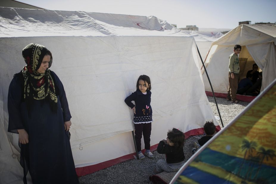 Residents stand between tents in a temporary camp erected for quake survivors in Sarpol-e Zahab.
