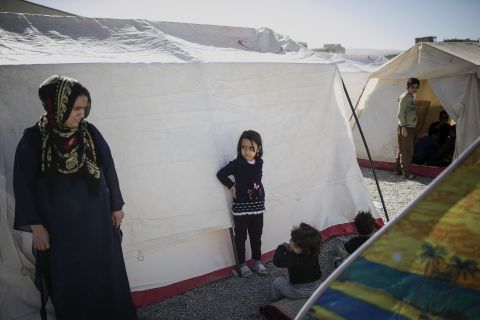 Residents stand between tents in a temporary camp erected for quake survivors in Sarpol-e Zahab.