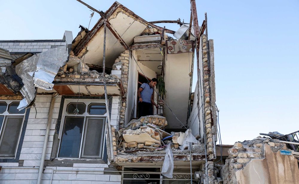 A man searches through a damaged building in Sarpol-e Zahab.