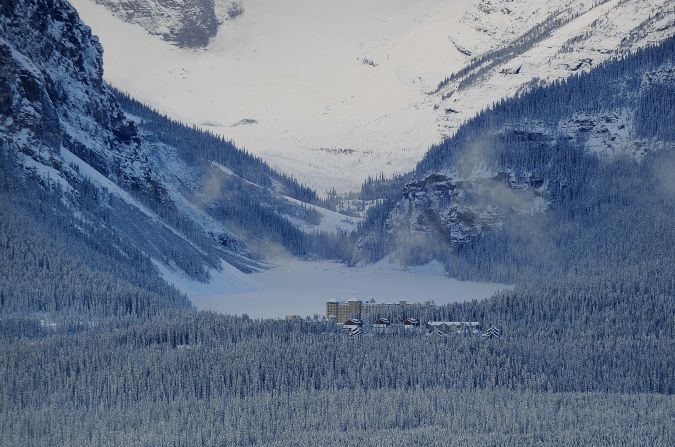 The iconic luxury Fairmont Chateau Lake Louise Hotel sits on the shore of the eponymous lake, which is snow covered in winter and a piercing emerald green in the summer. 