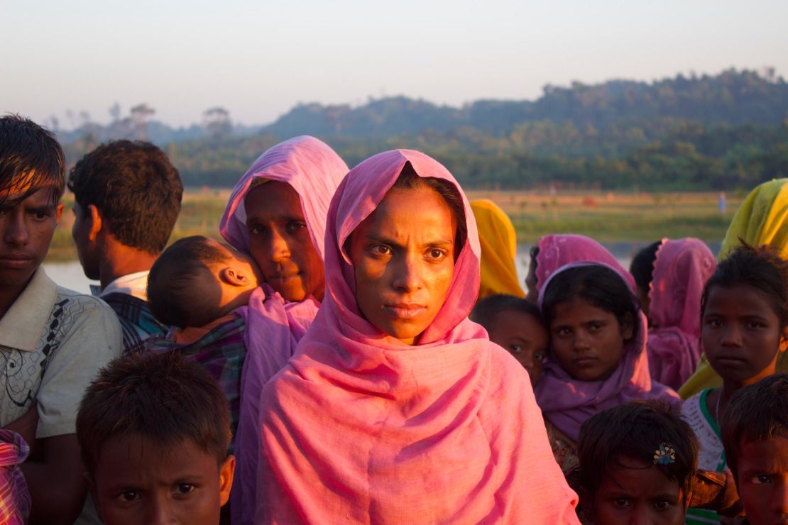 A group of Rohingya refugees, including this pregnant woman, wait on the roadside to hitchhike to nearby refugee camps.  