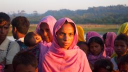 Rohingya refugees wait on the road side to hitchhike to nearby refugee camps. This nine-month pregnant woman had arrived with a larger group on fishing boats in the middle of the night to avoid detection by the Bangladesh coast guard. She said she did not have much to eat.  