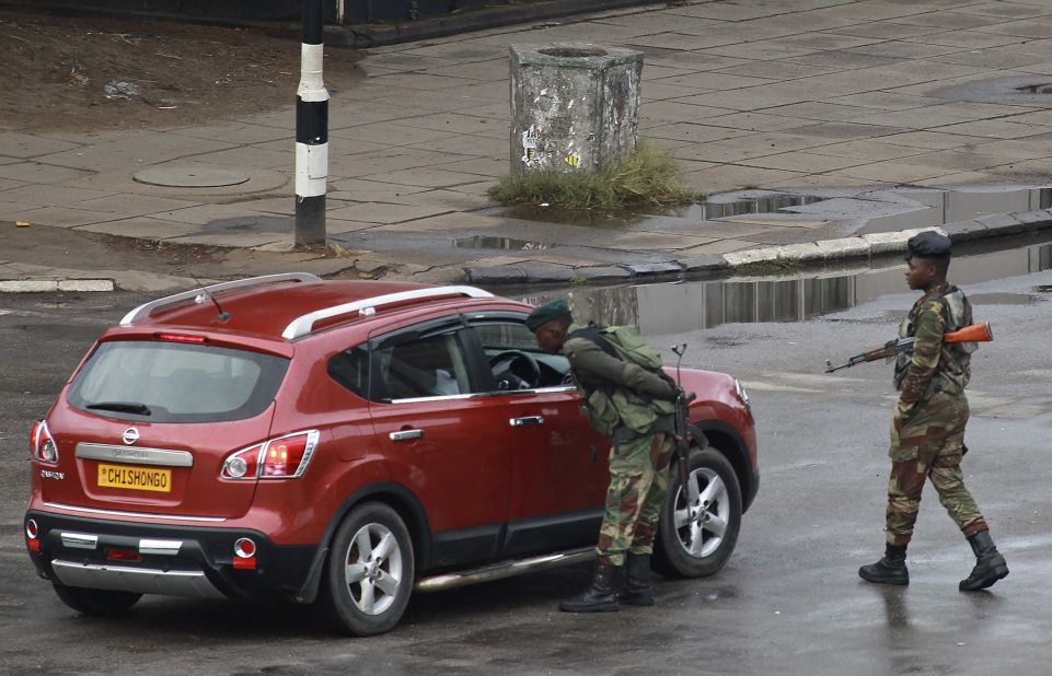 Soldiers inspect a vehicle on a road leading to Mugabe's office in Harare on November 15.