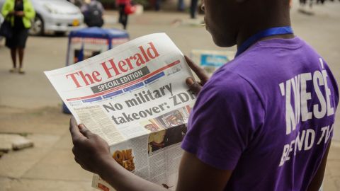 A man in Harare reads a special edition of The Herald newspaper on November 15.