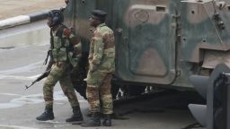 Armed soldiers stand by an armored vehicle on the road leading to President Robert Mugabe's office in Harare, Zimbabwe Wednesday, Nov. 15, 2017. Zimbabwe's army said Wednesday it has President Robert Mugabe and his wife in custody and is securing government offices and patrolling the capital's streets following a night of unrest that included a military takeover of the state broadcaster. (AP Photo/Tsvangirayi Mukwazhi)