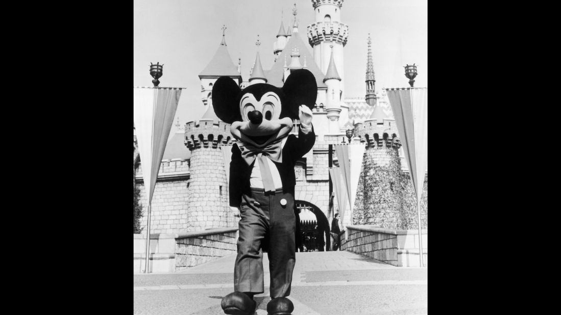 A person in a Mickey Mouse costume at the gate of the Magic Kingdom at the Disneyland theme park, Anaheim, California circa 1955.  