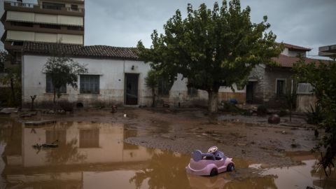 A toy car drifts on a flooded street next to a damaged house in Mandra on Wednesday.