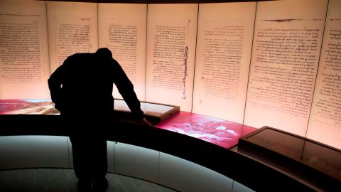 A visitors looks at an exhibit about the Dead Sea Scrolls during a media preview of the new Museum of the Bible.