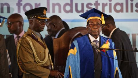 Zimbabwe's President Robert Mugabe, right, arrives at the Zimbabwe Open University in Harare.