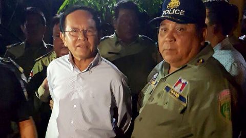 Cambodian opposition leader Kem Sokha (left) is escorted by police at his home in Phnom Penh on September 3, 2017. 