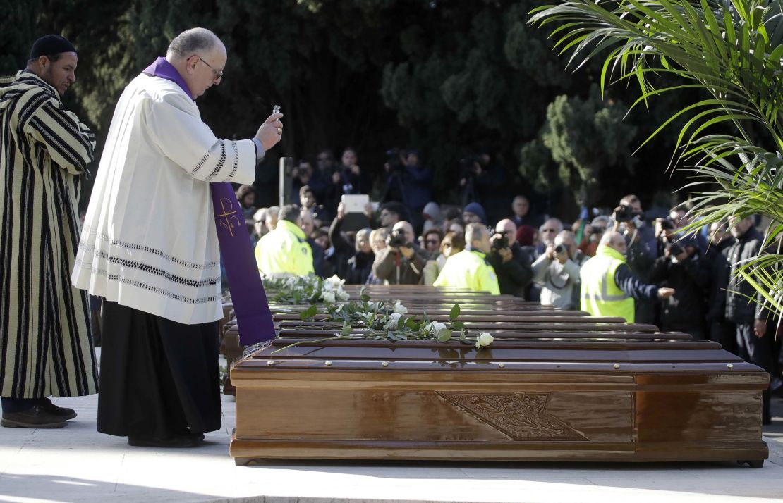 Monsignor Luigi Moretti blesses the coffins of the 26 Nigerian women.