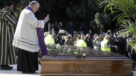 Monsignor Luigi Moretti blesses the coffins of the 26 Nigerian women.