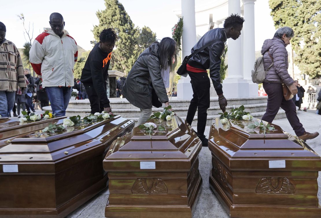 People touch the coffins after the memorial service.