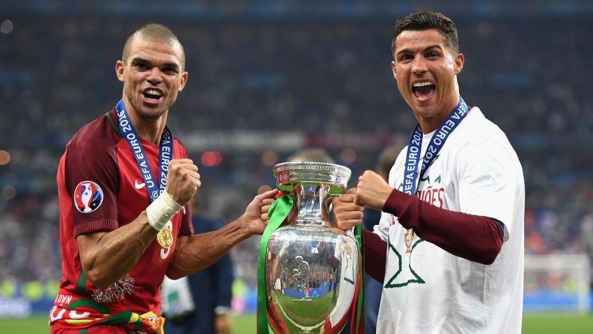 PARIS, FRANCE - JULY 10:  Cristiano Ronaldo (R) and Pepe (L) of Portugal pose for photographs holding the Henri Delaunay trophy to celebrate after their 1-0 win against France in the UEFA EURO 2016 Final match between Portugal and France at Stade de France on July 10, 2016 in Paris, France.  (Photo by Laurence Griffiths/Getty Images)