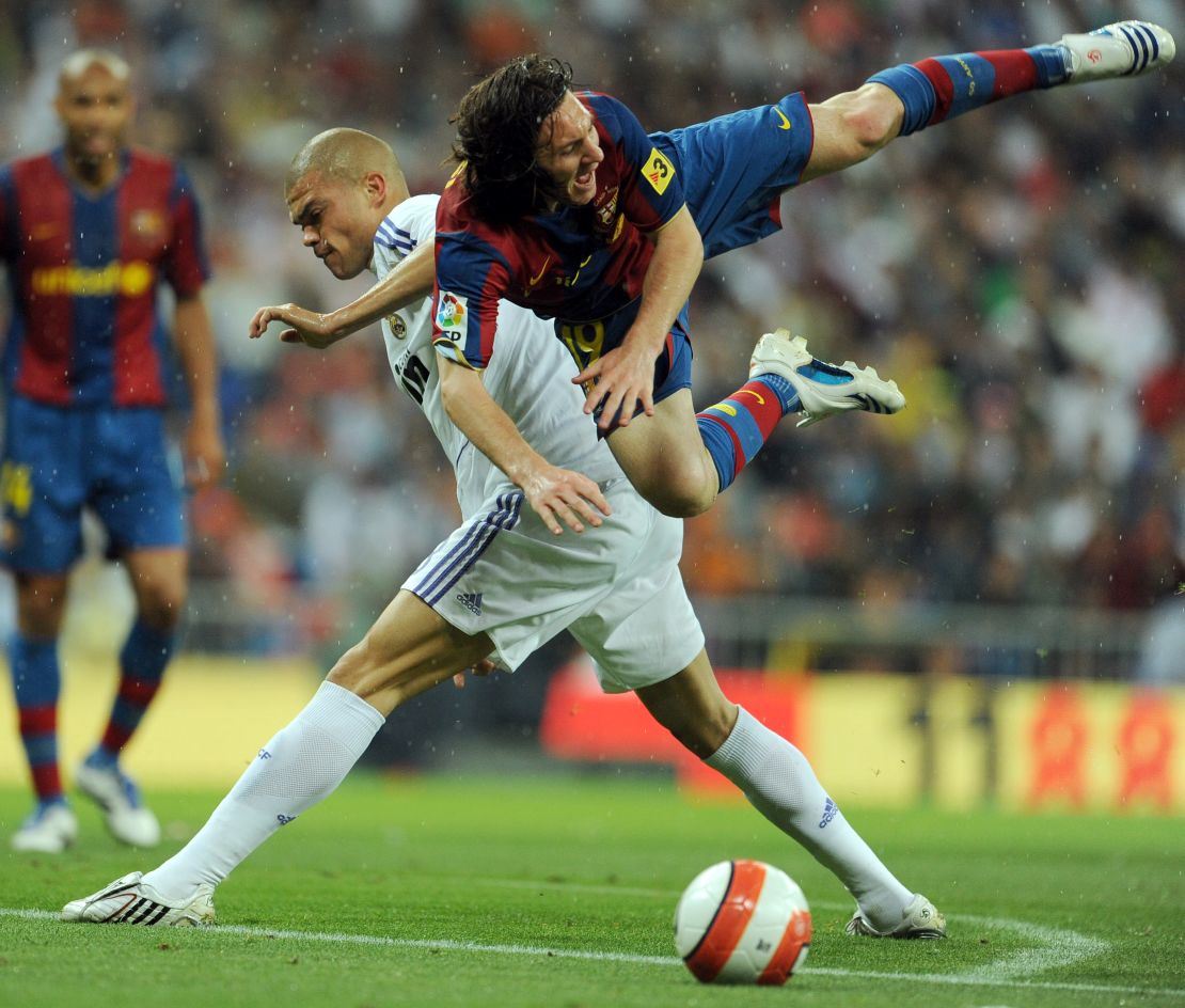 The ever combative Pepe vies with Lionel Messi. 