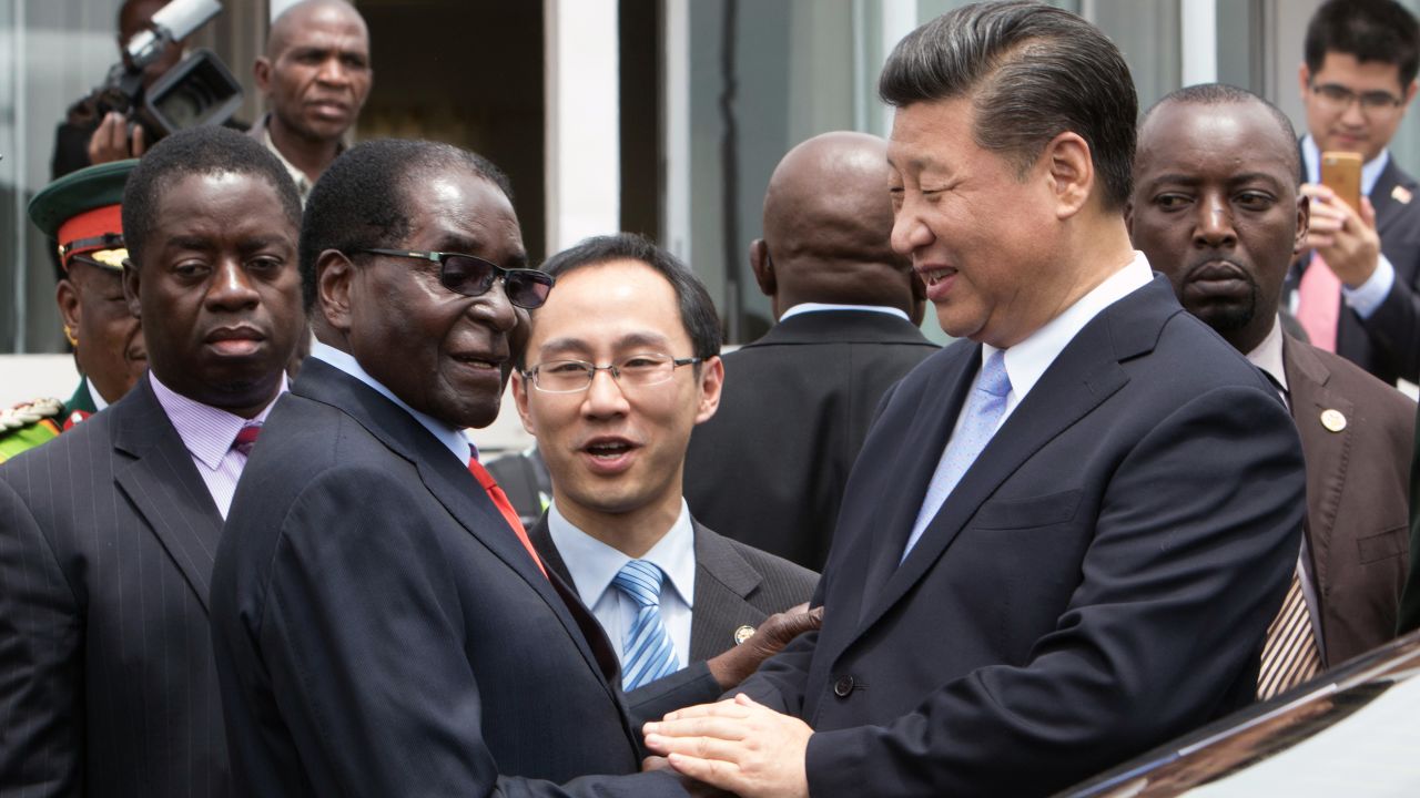 Xi shakes hands with Mugabe as he arrives on December 1 in Harare. 
