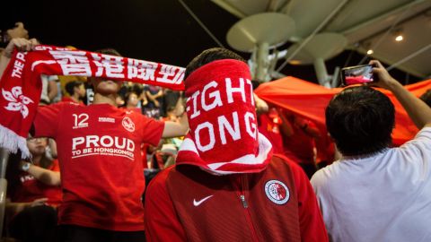 A Hong Kong fan covers his face during the Chinese national anthem before the match between Hong Kong and Bahrain on November 9, 2017.
