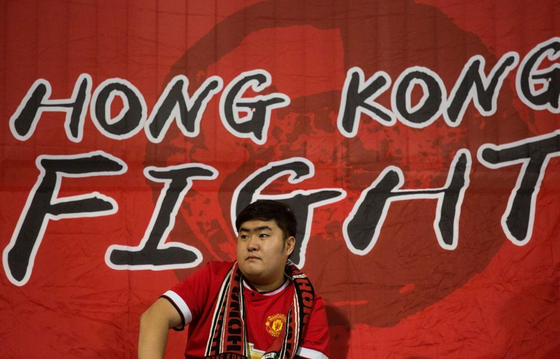 A Hong Kong fan sits in front of a flag before an international friendly football match between Hong Kong and Bahrain at Mong Kok Stadium in Hong Kong on November 9, 2017. 