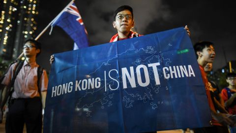 In this October 10, 2017 photograph, a flag that reads "Hong Kong is not China" is displayed by a local football fan in front of the old British colonial flag after a match between Hong Kong and Malaysia in Hong Kong.
