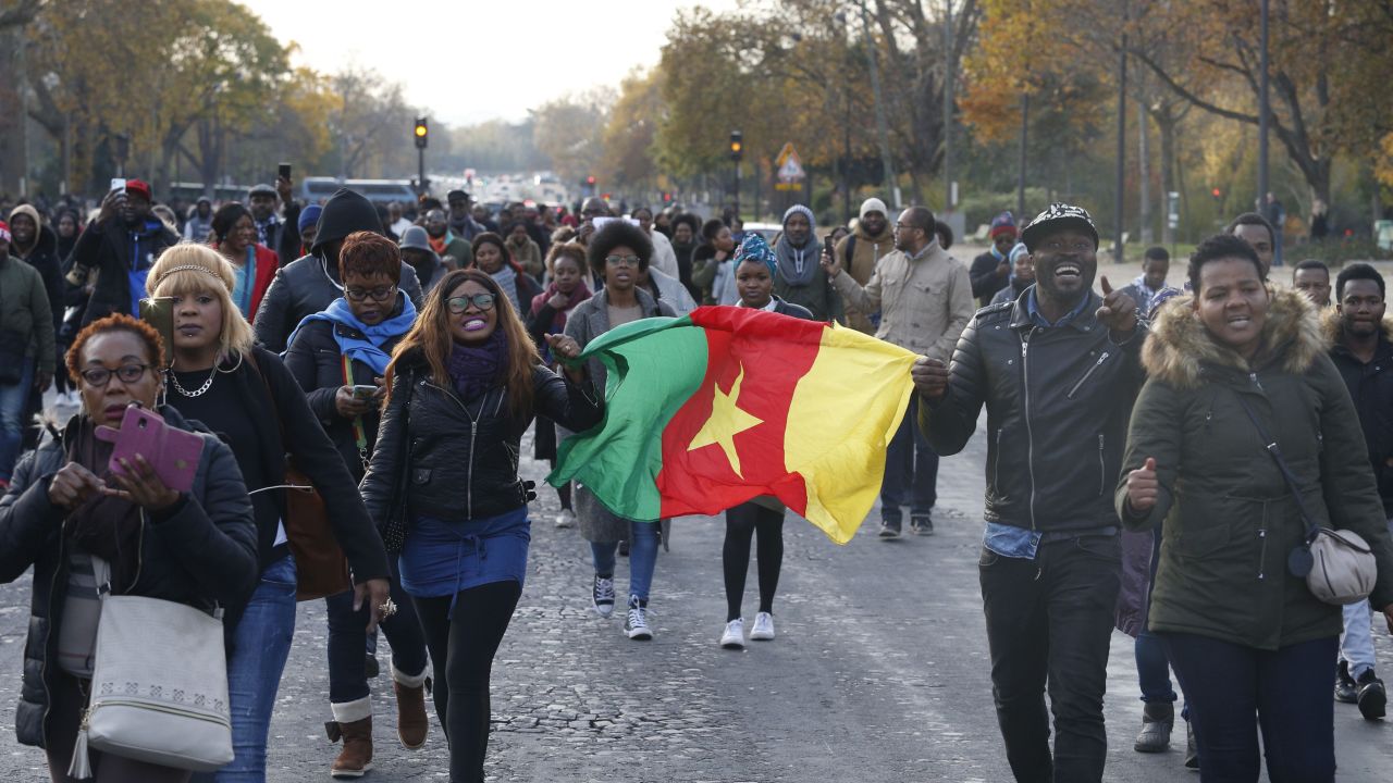 A woman holds a flag of Cameroon during a march against "slavery in Libya" on November 18 in Paris. 