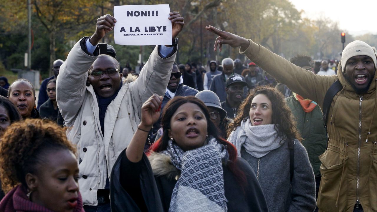 A man holds a placard reading "No to slavery in Libya" during a march against "slavery in Libya" on November 18, 2017 in Paris.