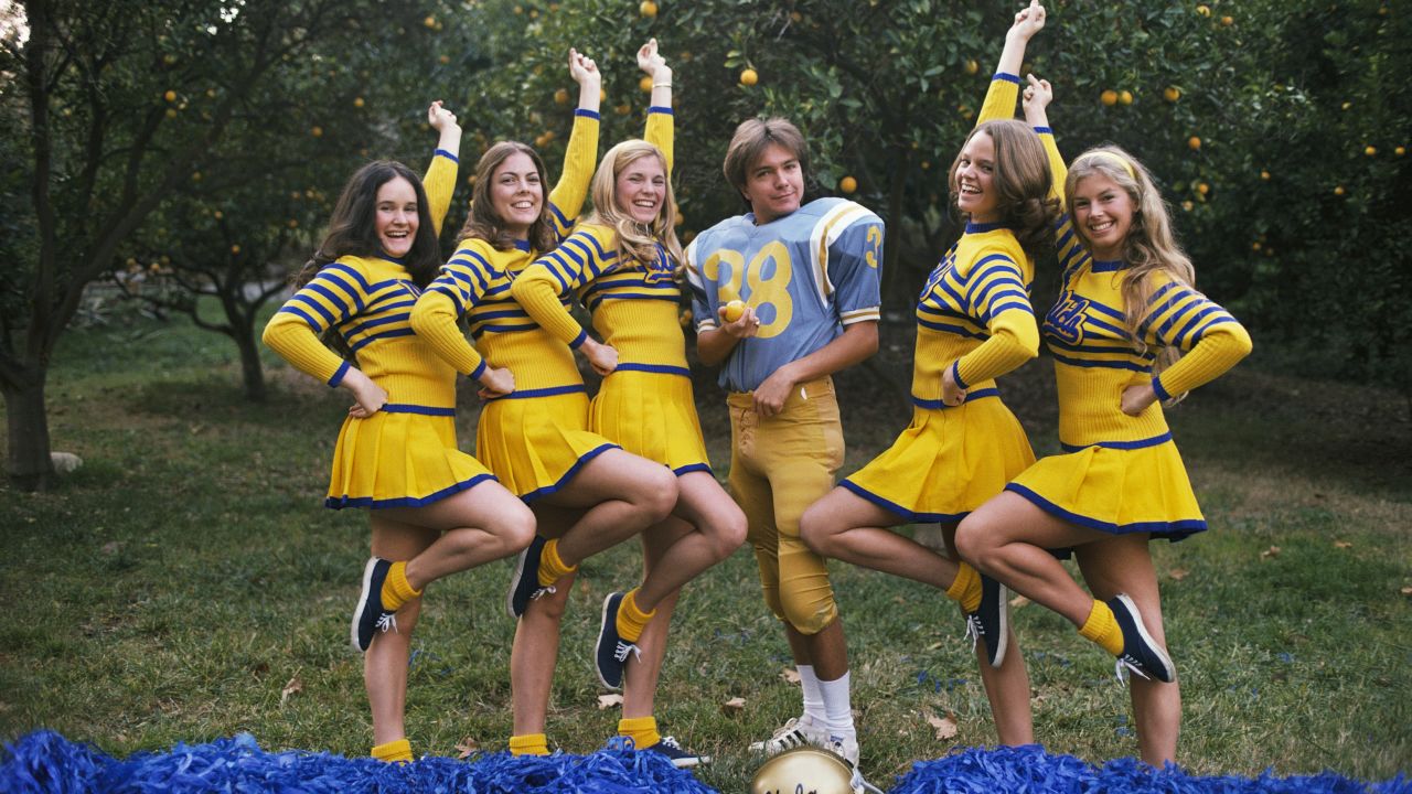 Ever the ladies' man, Cassidy poses in a UCLA football uniform flanked by five cheerleaders.