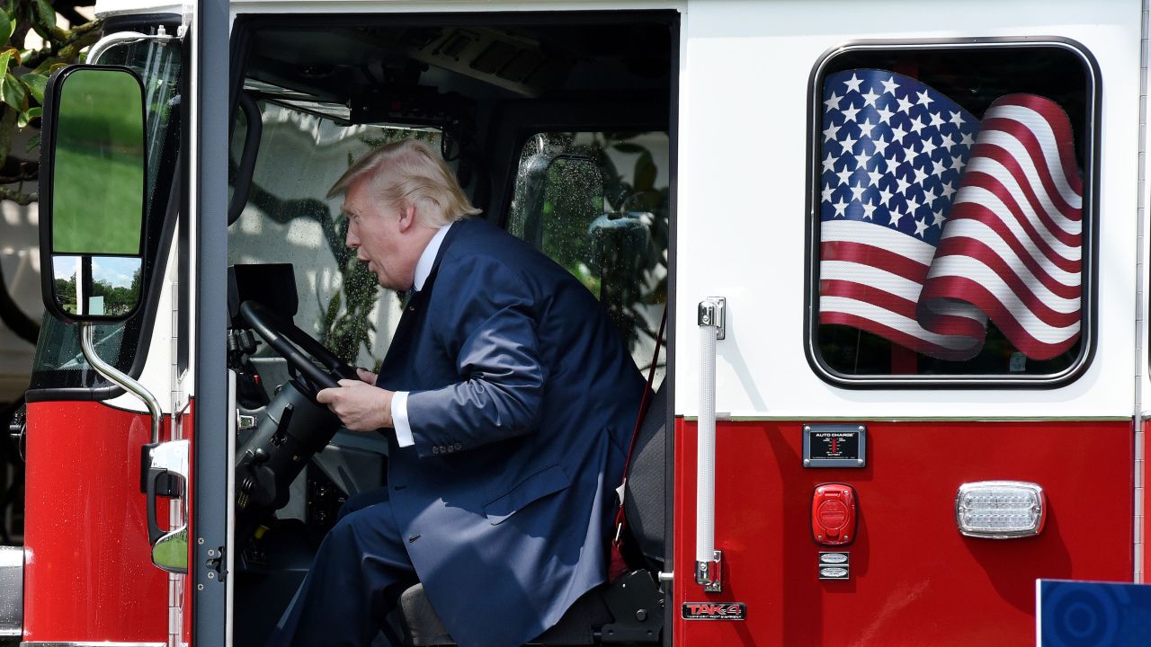 President Trump plays in a fire truck as the media looks on. Critics say Americans have lowered their presidential standards since Trump took office.