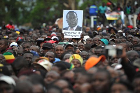 People hold a portrait of Zimbabwe's former vice president, Emmerson Mnangagwa, during a demonstration demanding Mugabe's resignation on November 18. ZANU-PF announced Mnangagwa as its new party leader. He was fired by Mugabe on November 6.
