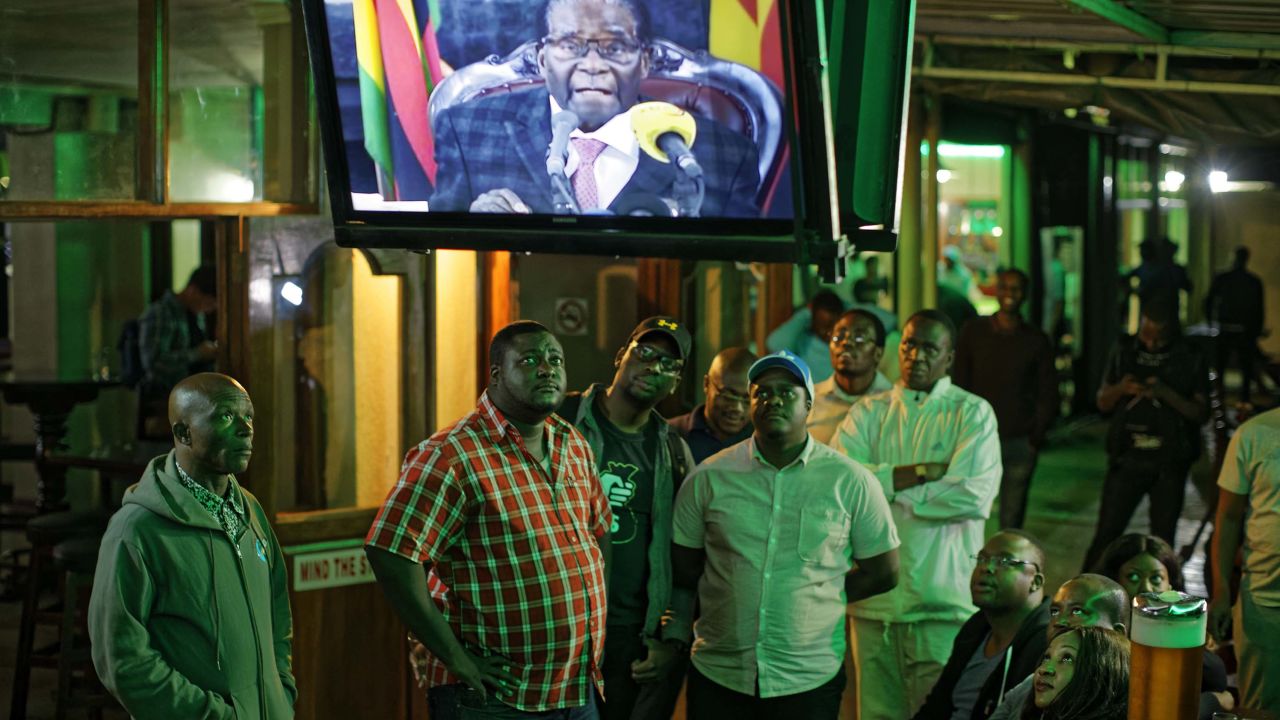 Zimbabweans watch Mugabe's televised address to the nation at a bar in downtown Harare Sunday.