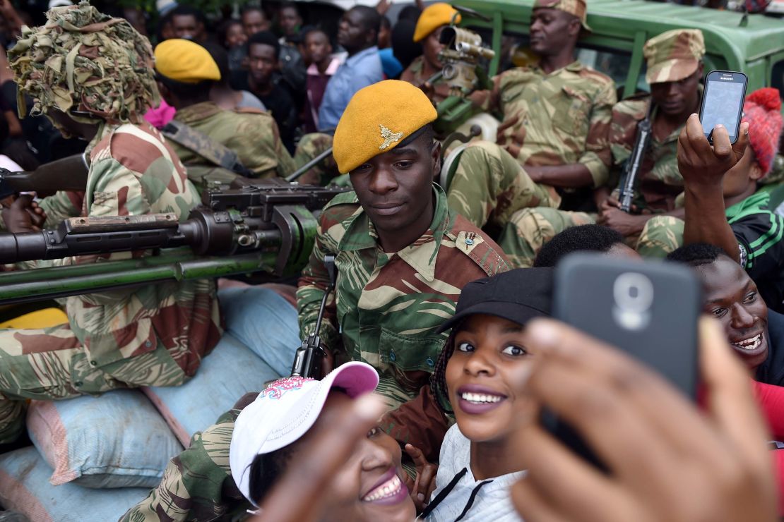 A soldier poses for a selfie with two women at a march in Harare on Saturday.