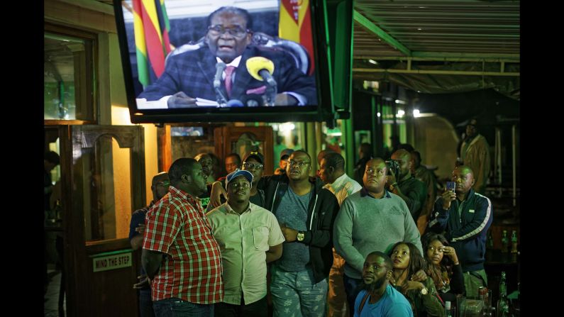 At a bar in Harare, people watch Mugabe give a televised address to the nation on Sunday, November 19. Mugabe ended <a href="index.php?page=&url=http%3A%2F%2Fwww.cnn.com%2F2017%2F11%2F19%2Fafrica%2Fzimbabwe-mugabe-party-meeting%2Findex.html" target="_blank">the address</a> without giving his resignation.