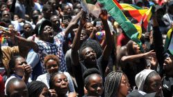A man holding a flag of Zimbabwe takes part in a demonstration of University of Zimbabwe's students, on November 20, 2017 in Harare, to demand the withdrawal of Grace Mugabe's doctorate and refused to sit their exams as pressure builds on Zimbabwe's President Robert Mugabe to resign.Zimbabwe's President faced the threat of impeachment by his own party on November 20, 2017, after his shock insistence he still holds power in Zimbabwe despite a military takeover and a noon deadline to end his 37-year autocratic rule. / AFP PHOTO / -        (Photo credit should read -/AFP/Getty Images)