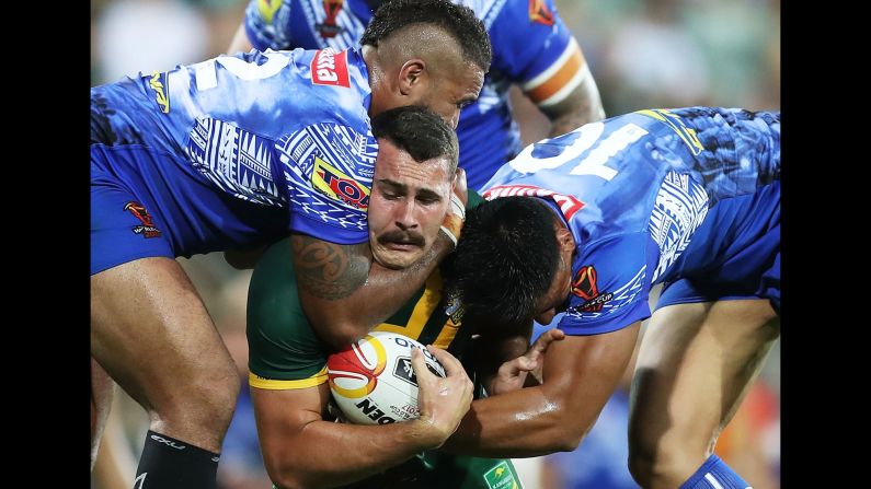 Australian's Reagan Campbell-Gillard is tackled by Samoa players during the quarterfinals of the Rugby League World Cup on Friday, November 17.