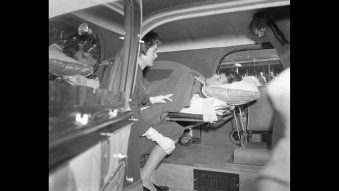Accompanied by his wife, Jackie, Kennedy leaves the hospital to be with family for the holidays two months after the 1954 spinal fusion surgery. It took that long to overcome the complications.