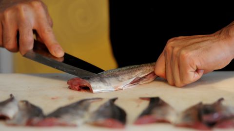 A Japanese chef slices sea bream during a sushi demonstration.