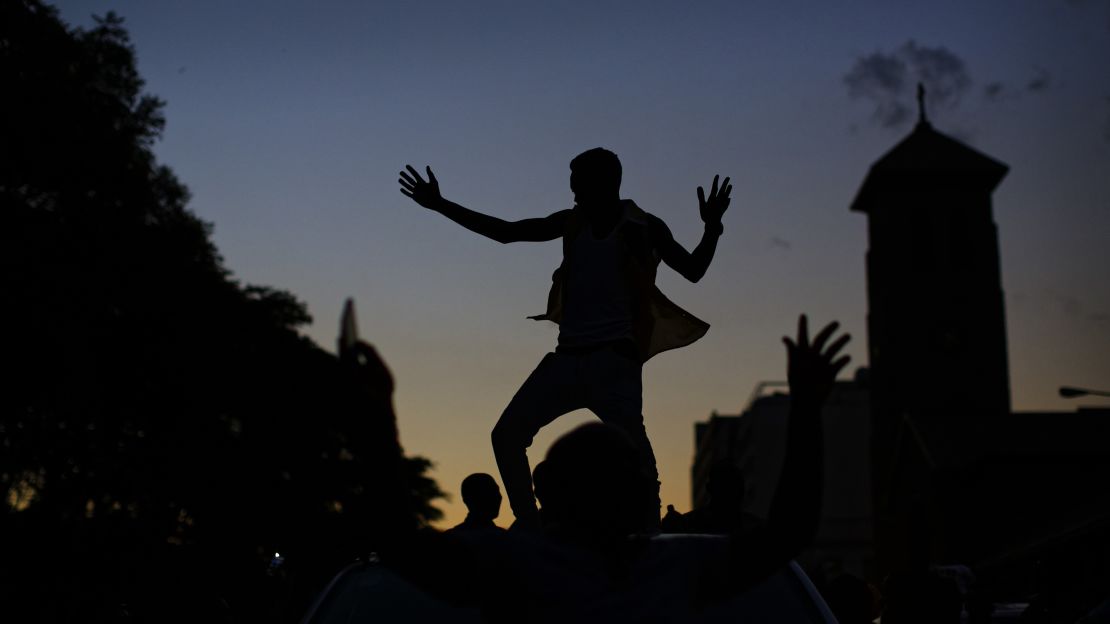 A Zimbabwean dances on the roof of a vehicle as the sun goes down in Harare on Tuesday. 
