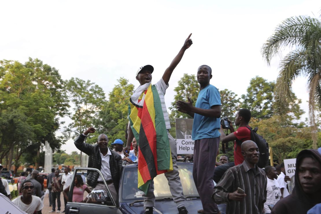Zimbabweans raise their fists at the news of Robert Mugabe's resignation.