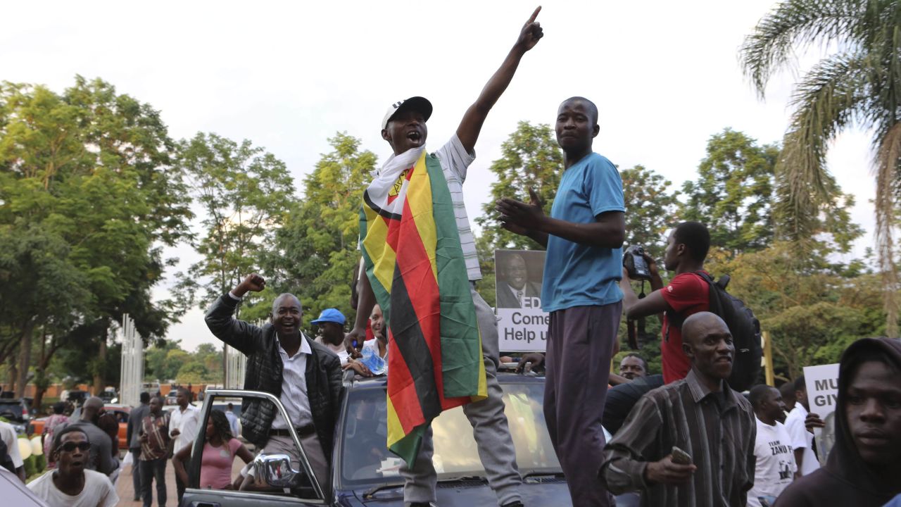 Zimbabweans raise their fists at the news of Robert Mugabe's resignation.