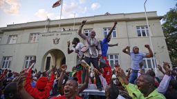 Zimbabweans celebrate outside the parliament building immediately after hearing the news that President Robert Mugabe had resigned, in downtown Harare, Zimbabwe Tuesday, Nov. 21, 2017. Mugabe resigned as president with immediate effect Tuesday after 37 years in power, shortly after parliament began impeachment proceedings against him. (AP Photo/Ben Curtis)