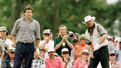 Faldo (left) watches playing partner Greg Norman tee off on the first hole during third round of play in the Masters.