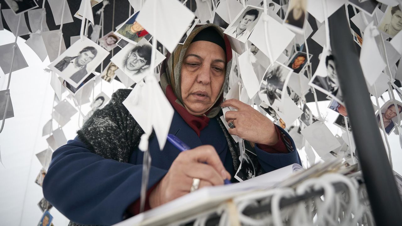 A woman writes in a book inside a traveling monument called "Prijedor 92" outside the tribunal in The Hague on Wednesday.